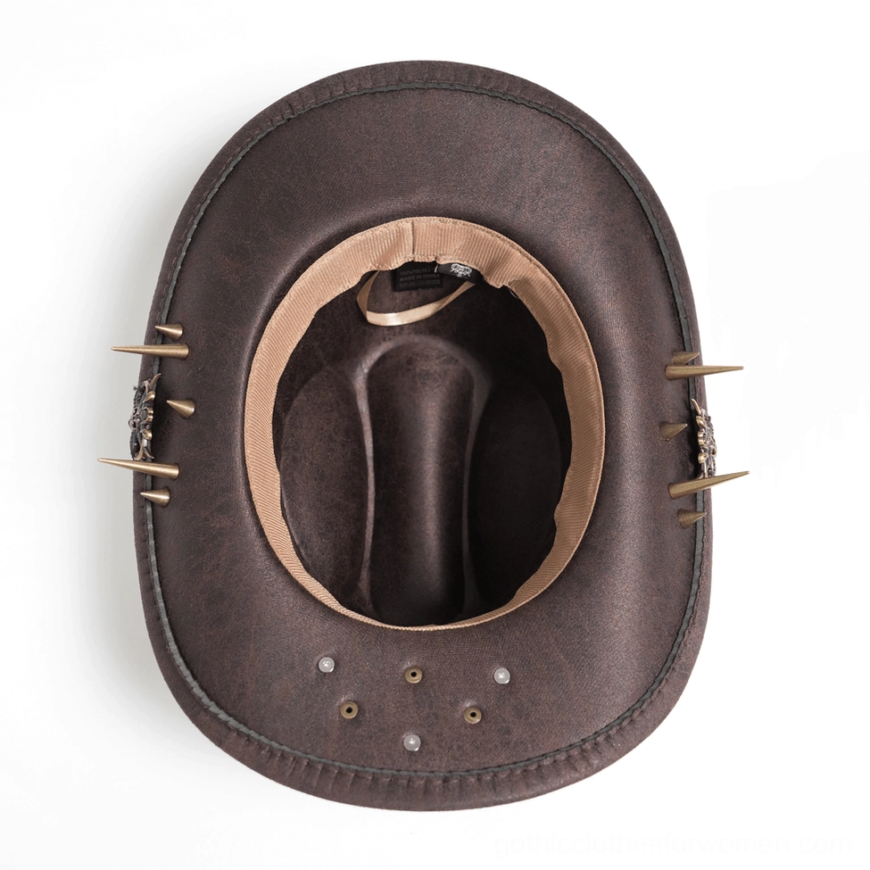 Brown gothic cowboy hat interior showing metal spike trims and tan lining, overhead view