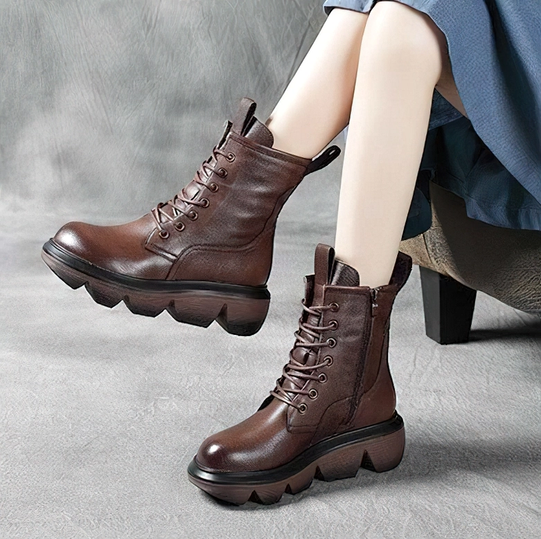 Brown gothic platform combat boots styled with model wearing blue skirt, grey concrete background