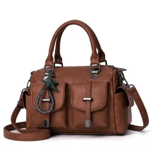 Brown tan vintage leather boston handbag with star pendant charm and multi-pocket design - flat lay studio shot
