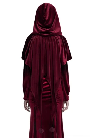 Burgundy velvet hooded gothic cape on mannequin, back view displaying flowing draped fabric and pom pom ties at hem