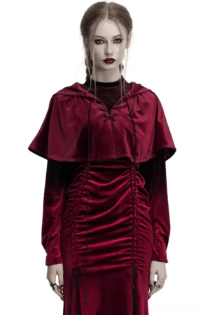 Burgundy velvet gothic hooded cape worn by female model, front view showing lace-up closure and irregular pointed hem with pom pom details