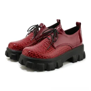 Burgundy wine-dark snake-grain patent leather lace-up pump, studio shot three-quarter perspective, alternative fashion platform heel