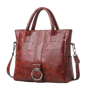 Burgundy vintage leather tote bag with decorative metal ring and dual carry handles