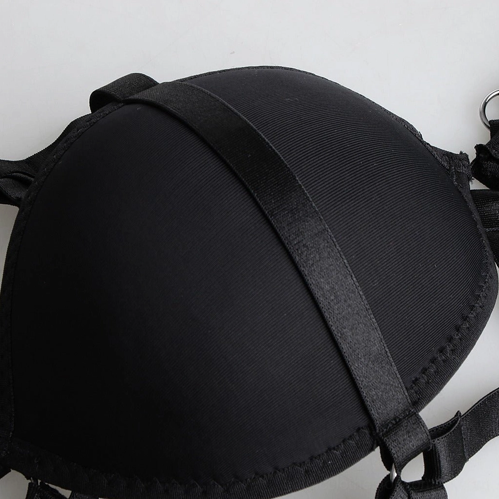Close-up detail of black cage harness nylon bra cup with attached straps and metal hardware