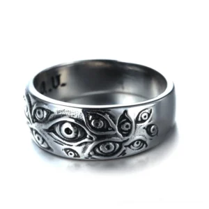 Vintage punk carved eyes ring front-facing full view displaying multiple engraved eye motifs across polished silver metal band with inner A.U stamp