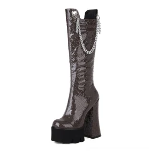 Coffee brown gothic patent leather knee-high platform boots with silver chain accent, square heel, quilted texture details, front-facing studio photography
