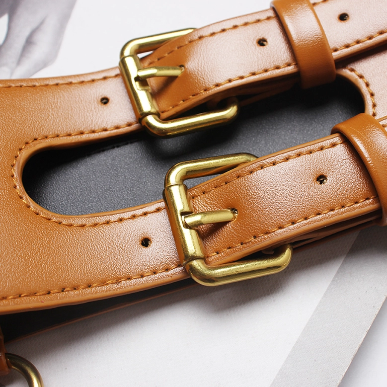 Close-up of tan leather corset belt with dual gold buckles and stitched edges detail
