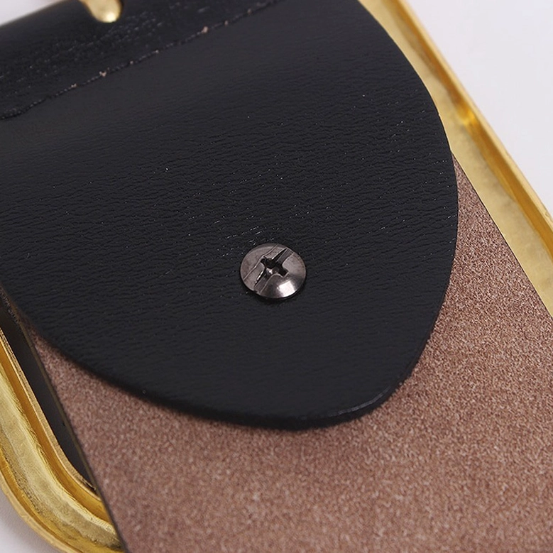 Close-up of belt buckle mechanism with black leather flap and silver screw fastener