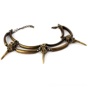Vintage crow skull layered bracelet in antiqued bronze, flat lay product photography featuring bird skull charms on white background