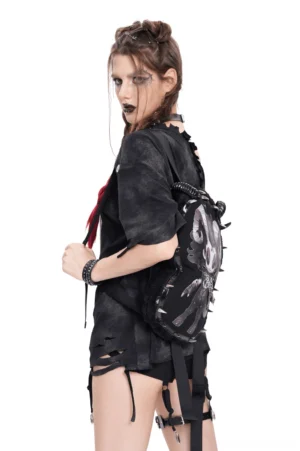 Side rear view of demon-themed gothic backpack showing fuzzy black fleece fabric and adjustable shoulder straps