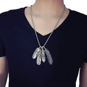 Feather gothic pendant necklace worn on male model - silver turquoise vintage feather charms figaro chain close-up