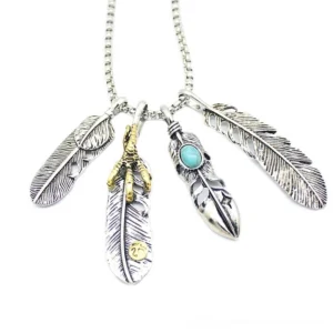 Four feather pendant necklace flat lay - multi-feather gothic design with silver gold turquoise stone details