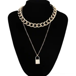 Gold padlock pendant necklace with dual chain construction featuring thick curb chain and delicate accent chain on black mannequin, gothic alternative jewelry style