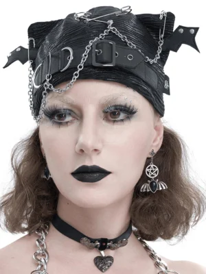 Black batwing gothic beanie with chains and buckles worn by goth model - front studio view showing detailed hardware and textured fabric