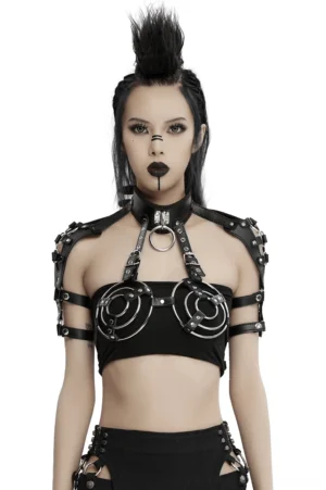 Black leather body harness with metal O-rings and adjustable shoulder straps worn by model with punk styling in studio portrait