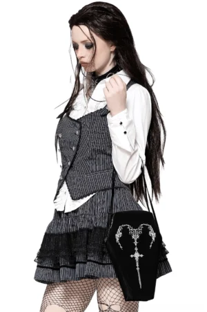 Gothic model wearing black coffin shoulder bag with embroidered sword design on shoulder three-quarter view
