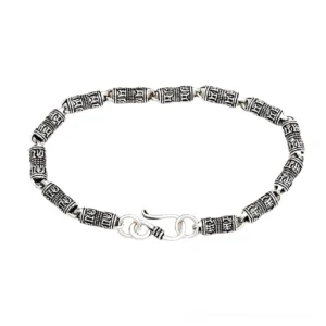 Gothic engraved 925 sterling silver cylindrical bracelet with hand-carved religious symbols and dual hook clasp, displayed in flat lay view showing detailed bead carvings