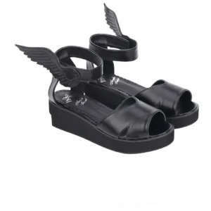 Black matte leather winged platform sandals side-front angle displaying wing decoration on ankle fastener and 5cm platform height