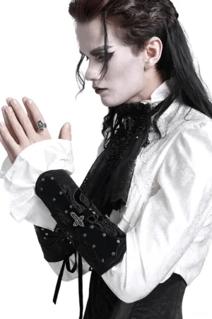 Male gothic fashion model wearing black synthetic leather arm bracers with cross pendant and lace-up closure, studio fashion photography