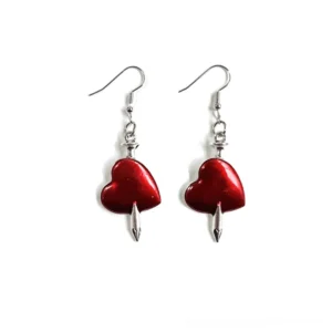 Silver arrow pierced red heart drop earrings gothic style jewelry flat lay front view