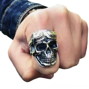 Aviator skull biker ring worn on male hand with denim sleeve showcasing the bold aged silver patina and substantial weight
