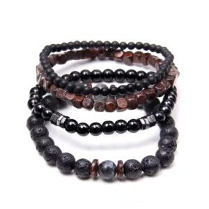 Dark aesthetic beaded bracelet collection overhead shot featuring lava stone black stone and natural wood beads with minimalist metal spacer accents