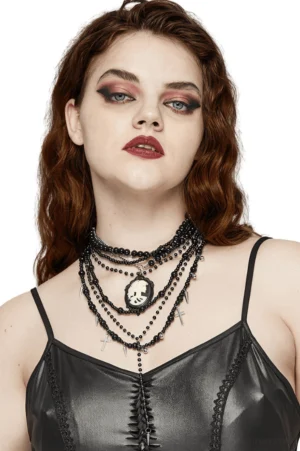 Gothic layered black beaded necklace with cameo and cross pendants worn by model, front close-up view