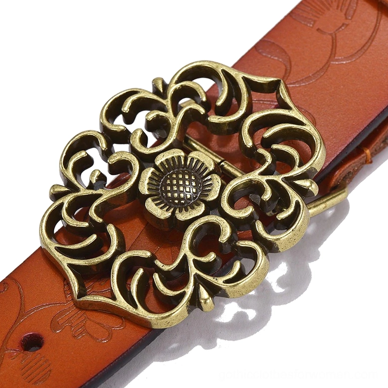 Close-up detail of gothic belt buckle and leather strap showing bronze geometric buckle with intricate detailing and tan leather embossing