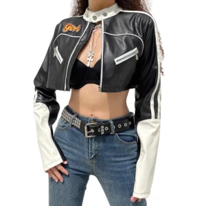Front view of black and white cropped leather biker jacket with zipper chest pockets and short hemline, worn by model