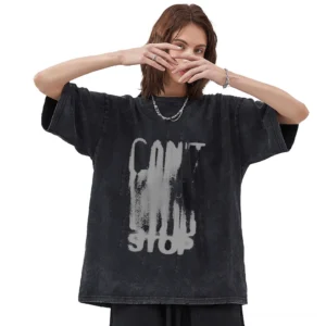 Female model wearing loose black cotton gothic t-shirt with distressed letter graphic print, front-facing studio shot demonstrating unisex oversized silhouette and crew neckline