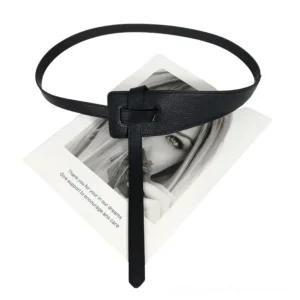 Black textured pebbled PU leather belt with sculptural knotted buckle, flat lay product display with artistic background