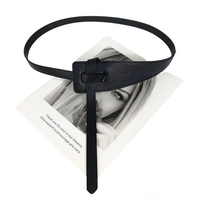 Black textured pebbled PU leather belt with sculptural knotted buckle, flat lay product display with artistic background