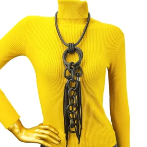 Black rubber gothic statement necklace with tassel fringe and linked metal rings displayed on mannequin in studio setting