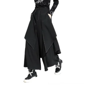 Black gothic wide leg trousers with pleated waist and asymmetrical drape, side three-quarter view showcasing flowing silhouette and contrast topstitching details
