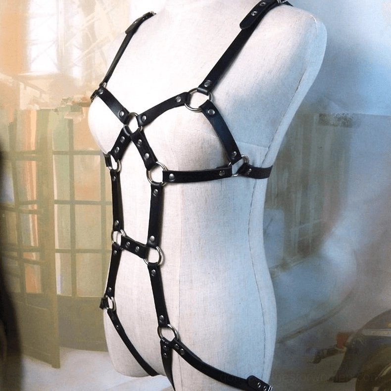 Black bondage body harness styled with alternative fashion outfit flat lay