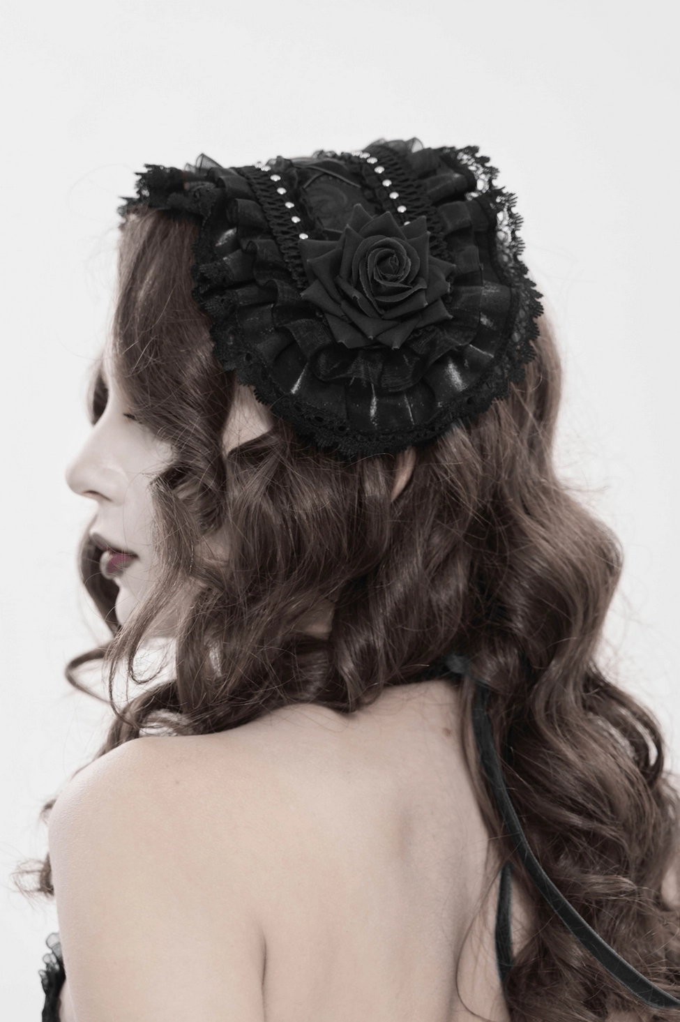 Gothic lace bonnet displayed from angle view showing layered construction, rose decoration, and ribbon tie functionality