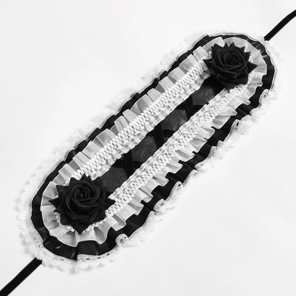 Flat lay top-down view of black and white gothic bonnet showing lace construction, black rose, and ribbon strap