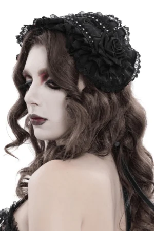 Black gothic lace bonnet with rose details shown on female model, left profile side view displaying layered ruffles and ribbon tie straps