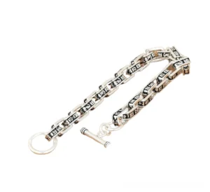 Engraved mantra text on square links of gothic sterling silver bracelet side flat lay