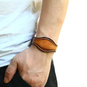 Wide vintage brown leather gothic cuff bracelet worn on male wrist - side view showing distressed leather edge detail