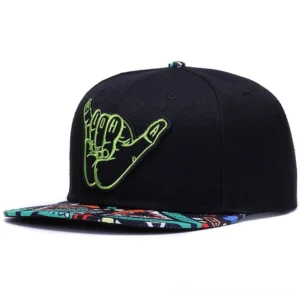 Front view of alternative style gothic cap featuring green shaka hand embroidery on black crown with geometric ethnic pattern brim