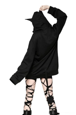 Black gothic cat-ear hoodie back view displaying oversized fit, heart-shaped tail detail at lower back, worn with strappy thigh-high tights and combat styling