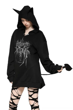 Black gothic oversized hoodie with cat ears and heart-shaped tail worn by female model, front three-quarter view showcasing dark metal graphic print and structured silhouette