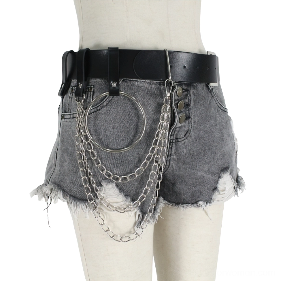 Left front side view of black chain belt harness worn on dress form with frayed denim shorts, showing silver chains and metal ring accent