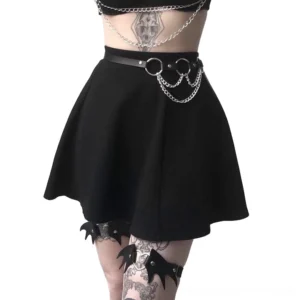 Black faux leather chain waist harness worn by female model in gothic styling, front upper body view showcasing silver chain details and alternative fashion aesthetic