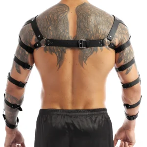 Black faux leather chest harness worn by model from front angle, demonstrating arm extensions and shoulder strap positioning
