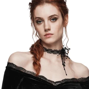 Black beaded spiderweb gothic choker with blood drop pendant worn on red-haired model in off-shoulder velvet dress, front upper-body view