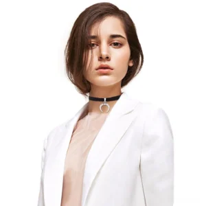 Woman wearing black velvet crescent moon choker with white blazer in studio portrait showcasing gothic everyday styling