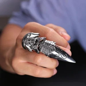 Gothic skull claw ring worn on adult hand, close-up front view showing finger armor design