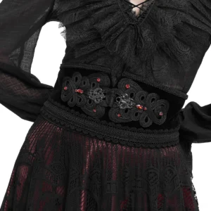 Close-up detail of beaded buckle with red gemstones and carved metal work on gothic corset belt